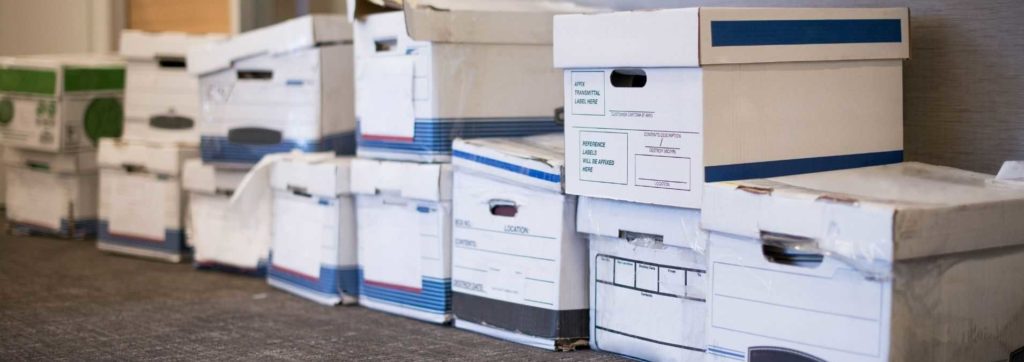 Boxes of files unorganized in store room